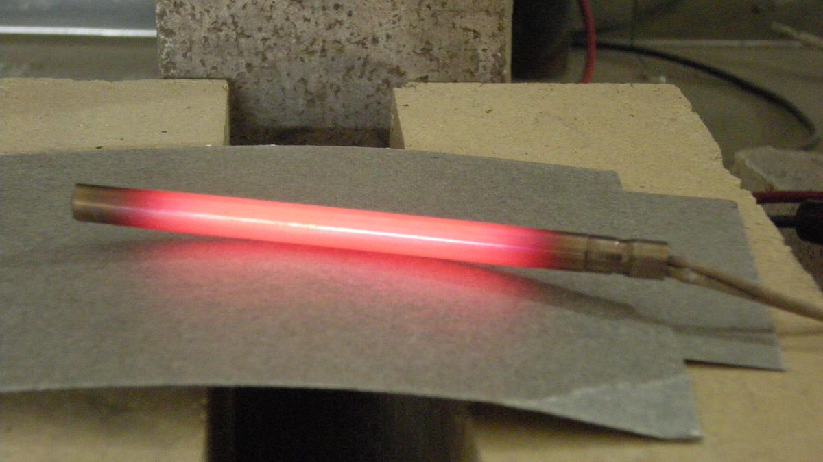 Electric current running through a cartridge heater, causing a red-hot glow due to low conductivity / high resistance. 