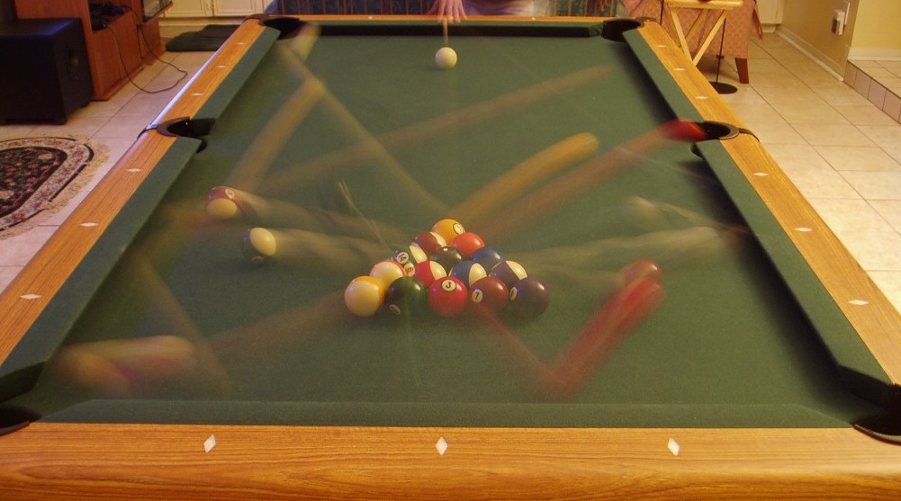 Before a game of 8-ball is started on a billiards table, the balls can only occupy one of 15 spaces within the <em>rack</em>. However, after the <em>break</em>, the balls are scattered to positions all around the table, so the <strong>entropy increases greatly</strong>.